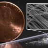 Fuzzy white clusters of nanowires on a lab bench, with a penny for scale. (Hao Yan/SIMES/SLAC National Accelerator Laboratory)