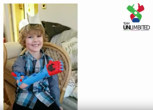 Team Unbilimited gifts a boy with a prosthetic arm. (YouTube)