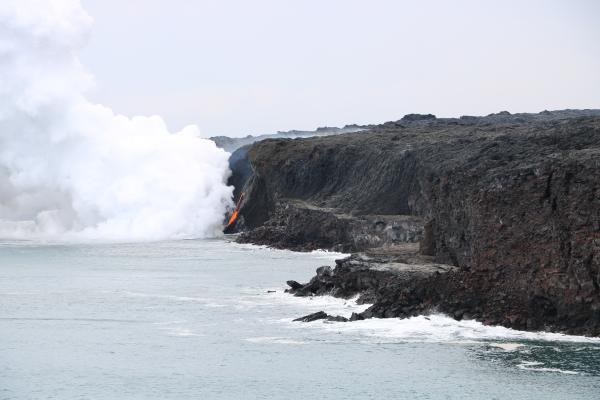The rocky shelf at the base of the sea cliff is all that remains of the Kamokuna lava delta following the New Year's Eve collapse. (USGS HVO)