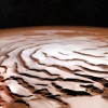 Perspective view of the Mars north polar ice cap and its distinctive dark troughs forming a spiral-like pattern. (ESA/DLR/FU Berlin; NASA MGS MOLA Science Team)
