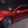 A Tesla Model 3 prototype is displayed on stage. 