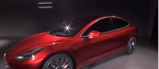 A Tesla Model 3 prototype is displayed on stage. 