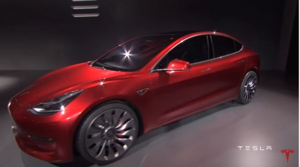 A Tesla Model 3 prototype is displayed on stage. 