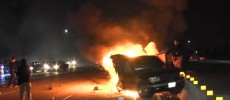 A car catches flame after it crashed into a concrete barrier.  (YouTube)