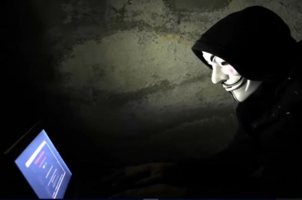  An anonymous hacker tinkers with his computer. 