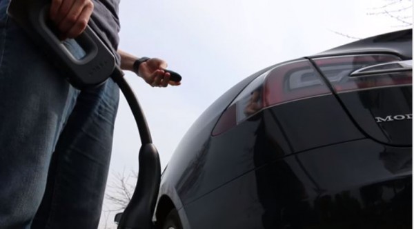 A Tesla car owner prepares to charge his car at one of the charging stations. 