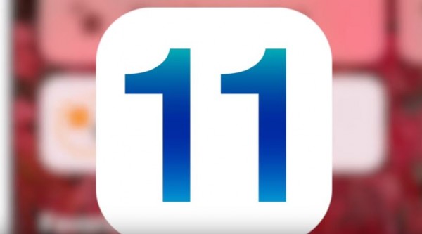 An iOS 11 logo is on display having an iPhone as its vague background. (YouTube)