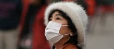 A woman in China covering her face due to dangerous pollution levels that take the lives of 1.6 million citizens each year.