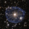 The distinctive blue bubble appearing to encircle WR 31a is a Wolf–Rayet nebula — an interstellar cloud of dust, hydrogen, helium and other gases.