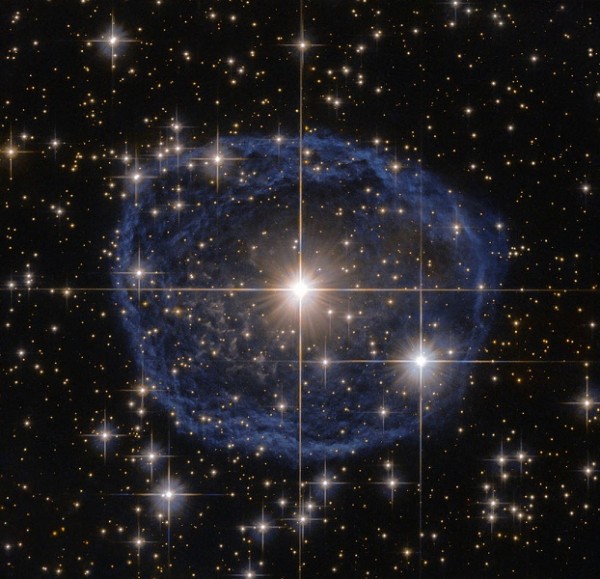 The distinctive blue bubble appearing to encircle WR 31a is a Wolf–Rayet nebula — an interstellar cloud of dust, hydrogen, helium and other gases.