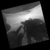 A shadow and tracks of NASA's Mars rover Opportunity appear in this March 22, 2016, image, which has been rotated 13.5 degrees to adjust for the tilt of the rover. The hillside descends to the left into 