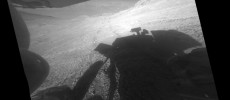 A shadow and tracks of NASA's Mars rover Opportunity appear in this March 22, 2016, image, which has been rotated 13.5 degrees to adjust for the tilt of the rover. The hillside descends to the left into 