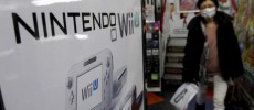 A woman walks past an advertisement board of Nintendo Co Ltd's Wii U game console.
