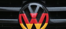 Volkswagen logo and hood ornament in the colors of the German flag is visible on the front grille of a car in Berlin, Germany. 