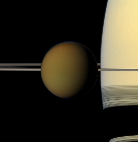 The hazy globe of Titan hangs in front of Saturn and its rings in this natural color view from NASA's Cassini spacecraft.