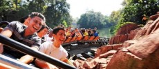 Guests ride aboard the Big Thunder Mountain Railroad roller coaster in Disney Land California.