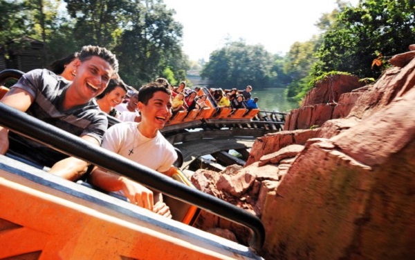 Guests ride aboard the Big Thunder Mountain Railroad roller coaster in Disney Land California.
