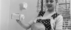 A young mother pours talcum powder over her baby daughter. 