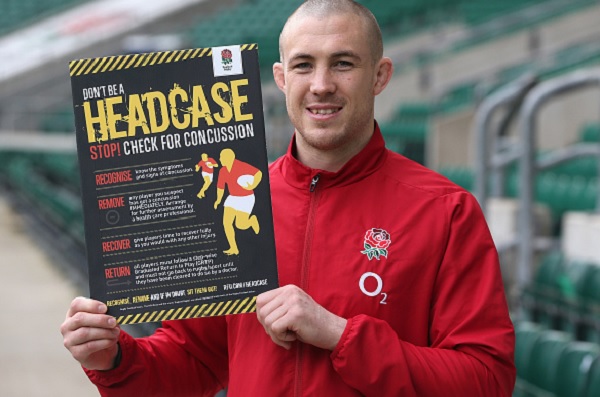  Mike Brown, the England fullback, is seen supporting the RFU's latest concussion awareness initiative with a promotional poster.