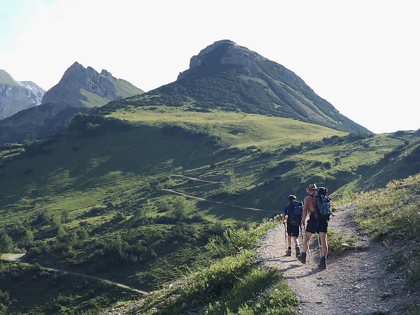 Hikers in the Karwendel mountain walk towards the Eng valley near Eng Alm, Austria. 