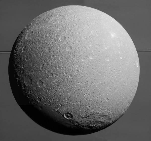 This view from NASA's Cassini spacecraft looks toward Saturn's icy moon Dione, with giant Saturn and its rings in the background.