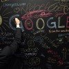A visitor writes on a chalkboard at the official opening party of the Google offices in Berlin, Germany. 
