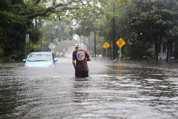 A man walks through a flooded street as Hurricane Matthew passes through the area in St Augustine, Florida.