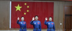 (L-R) Chinese astronauts of the Shenzhou-10 manned spacecraft mission Wang Yaping, Nie Haisheng and Zhang Xiaoguang sit in front of a Chinese national flag as they meet the media at the Jiuquan Satell