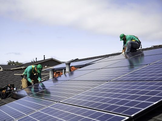 Workers installing a solar roof for San Mateo, California-based solar-panel company SolarCity Corp.