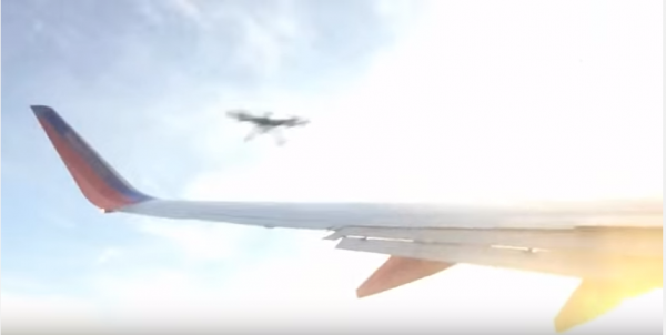 A drone approaching the wing of an airplane.