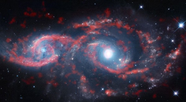 Galaxies IC 2163 (left) and NGC 2207 (right) recently grazed past each other, triggering a tsunami of stars and gas in IC 2163 and producing the dazzling eyelid-like features. (NASA)